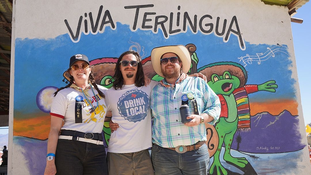 3 Friends in Terlingua posing in front of Viva Terlingua art